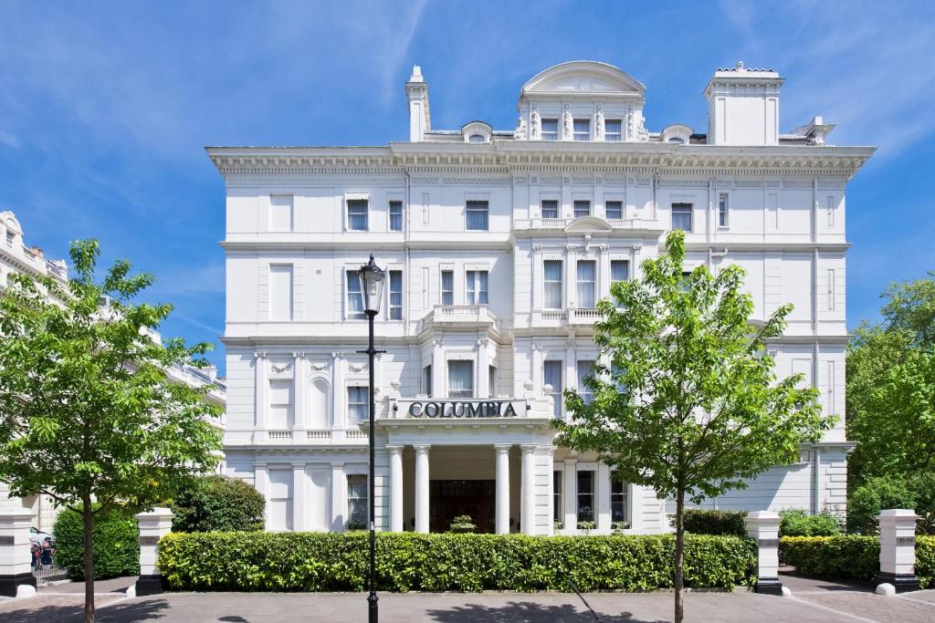 un edificio bianco con alberi di fronte di The Columbia a Londra