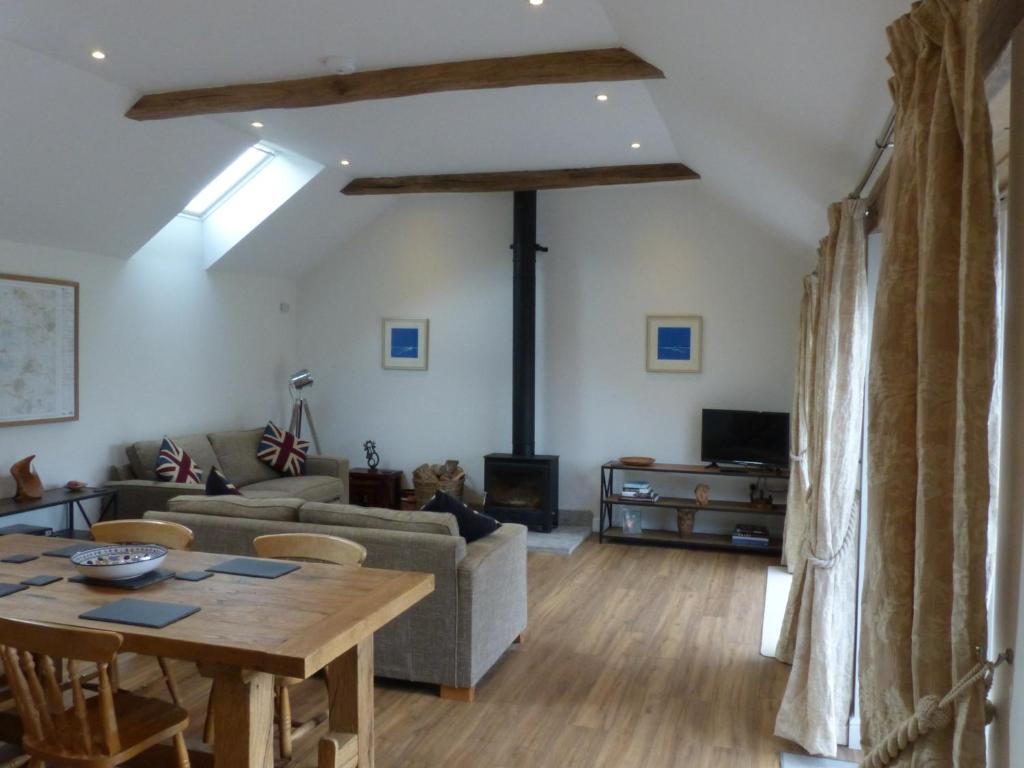 un soggiorno con un tavolo e un divano di The Woodshed - A newly built, 2 bedroom, cottage near Glastonbury a Glastonbury