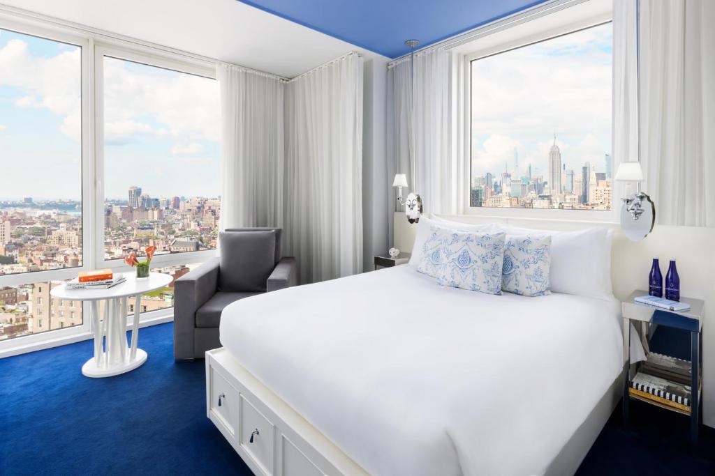 a hotel room with a bed and a large window at NoMo SoHo in New York