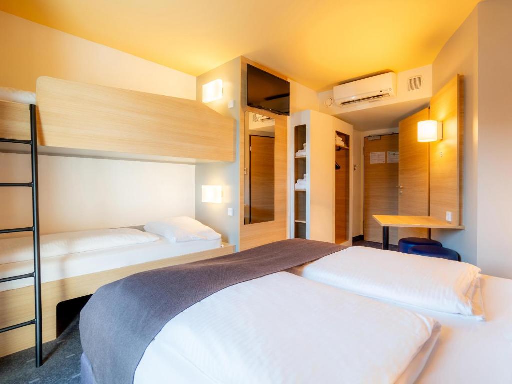 een slaapkamer met 2 stapelbedden en een bureau bij B&B Hotel Stuttgart-Bad Cannstatt in Stuttgart