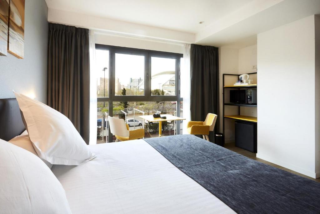 una habitación de hotel con una cama grande y una mesa en Sercotel Valencia Alameda 41, en Valencia