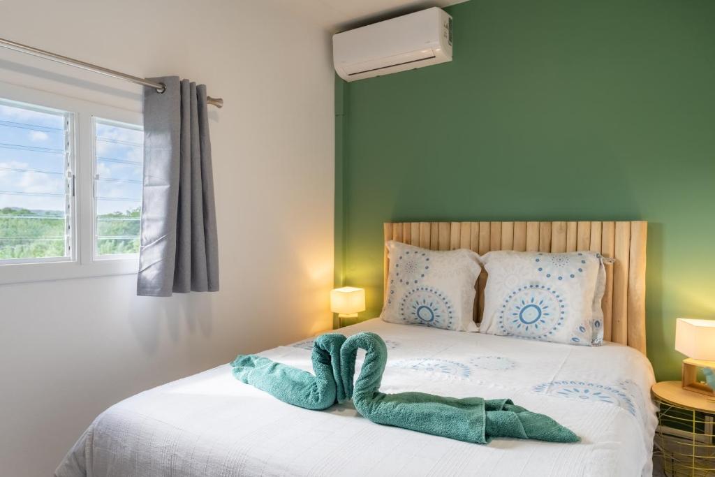 ein Schlafzimmer mit einem Bett und einem Handtuch darauf in der Unterkunft LODGE LE Filaos in Sainte-Anne