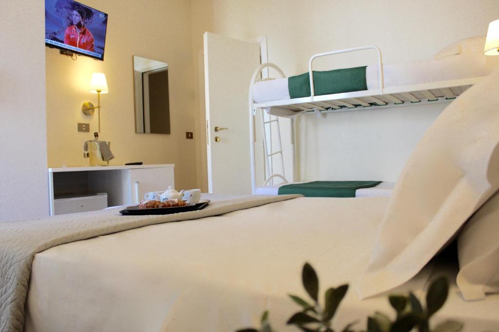 una camera con un letto e un vassoio di cibo sopra di King Hotel a Cesenatico