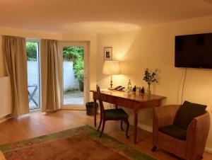 un soggiorno con scrivania, tavolo e sedie di Hotel Villa Meererbusch a Meerbusch