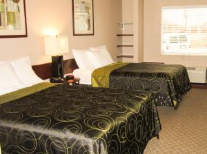 a hotel room with two beds and a couch at Bell's Extended Stay and Suites in Saint Robert +28 photos
