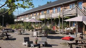 a building with tables and chairs and umbrellas at Amsterdam Farm Lodge in Amsterdam