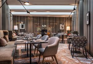 a restaurant with couches and tables and chairs at SO/ Berlin Das Stue in Berlin
