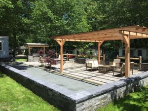 a gazebo with chairs and tables on a patio at Hanscom's Motel & Cottages in Bar Harbor