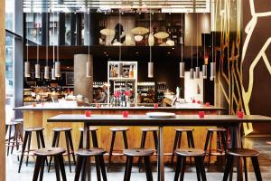 a bar in a restaurant with stools around it at citizenM New York Times Square in New York