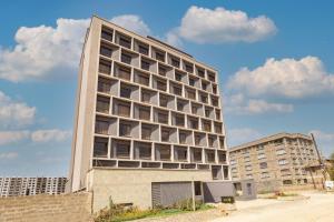 a tall building with many windows on the side of it at Kozi Suites Nairobi Airport in Nairobi