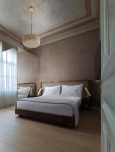 a bedroom with a bed with white pillows and a ceiling at Monument in Athens