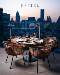 a table and chairs with a view of a city at Aira Hotel Bangkok Sukhumvit 11 in Bangkok