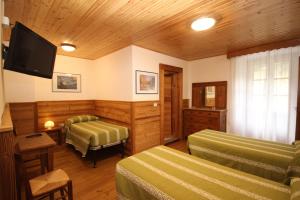 una camera d'albergo con due letti e una televisione di Hotel Col Du Mont ad Arvier