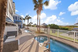 a swimming pool with palm trees and a building at Club Wyndham Westwinds in Myrtle Beach