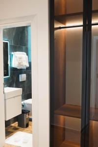 uma casa de banho com um lavatório, um WC e um espelho. em Marina Rooms em Durrës mais 37 fotografias