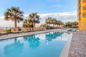 a pool with chairs and palm trees in a resort at Hilton Grand Vacations Club Anderson Ocean Myrtle Beach in Myrtle Beach