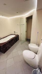 a bathroom with a tub and a toilet and a sink at Ora Place JBR in Dubai