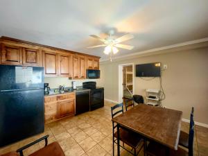 a kitchen with a table and a black refrigerator at Coco Loco in Myrtle Beach