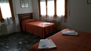 una camera con due letti in una stanza con finestre di Albergo Sonia a Firenze