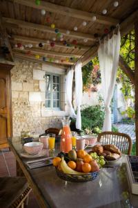 a table with a bowl of fruit on it at La Tillaie SPA et Sauna in Pont-lʼAbbé-dʼArnoult