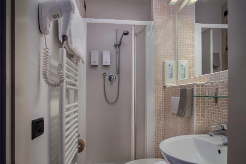 un bagno con doccia e lavandino di Hotel Kursaal & Ausonia a Firenze
