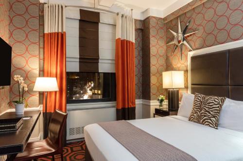 a hotel room with a bed and a desk and a window at The Empire Hotel New York in New York