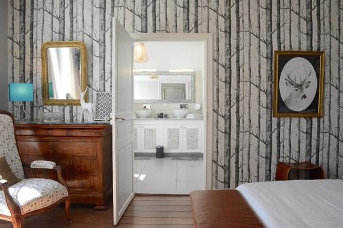 a bathroom with a sink and a mirror at La Tillaie SPA et Sauna in Pont-lʼAbbé-dʼArnoult