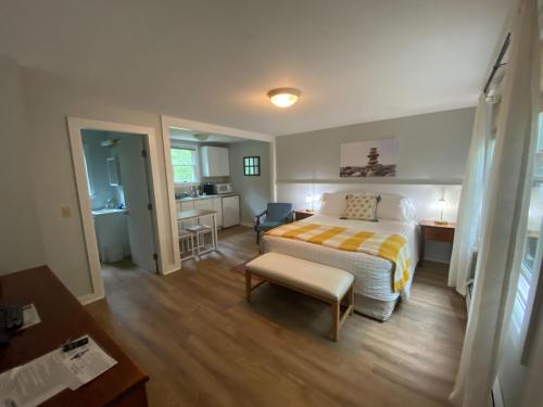 a bedroom with a bed and a desk and a kitchen at Hanscom's Motel & Cottages in Bar Harbor