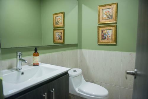 a bathroom with a sink and a toilet and a mirror at Casa Tangara Café y Hospedaje in Medellín