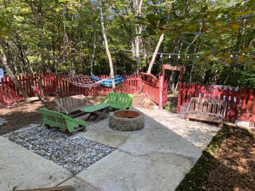 a playground with two green benches and a red fence at Wooden House Kopiti in Tbilisi City