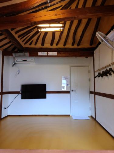 a large room with a stage and a white wall at Hanok Raon in Gyeongju