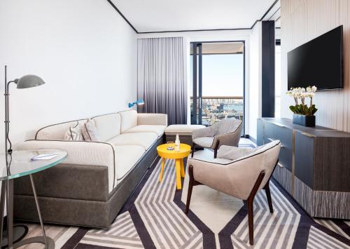 a living room with a couch and a tv at The William Vale in Brooklyn