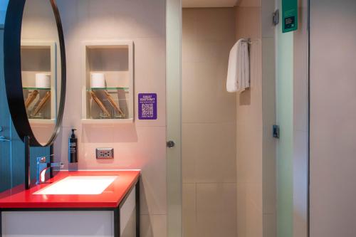a bathroom with a sink and a mirror at ibis Styles Manila Araneta City in Manila