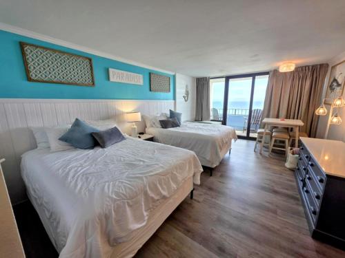 um quarto de hotel com duas camas e uma varanda em Newly Renovated Privately owned OF condo on 6th floor Ocean Reef with pools, hot tubs, lazy river and waterpark em Myrtle Beach