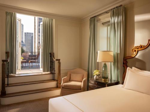a bedroom with a bed and a chair and a window at The Plaza in New York